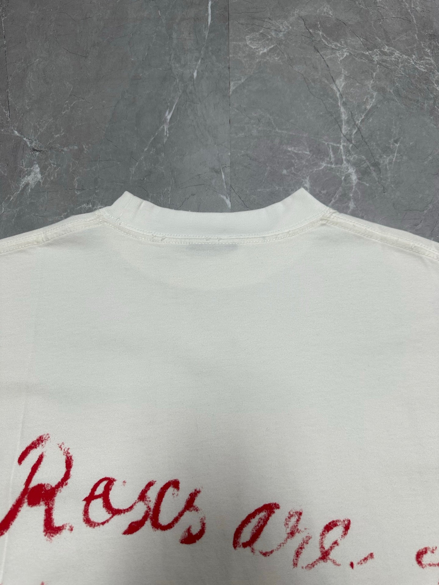 White T-shirt back close-up of red script logo text