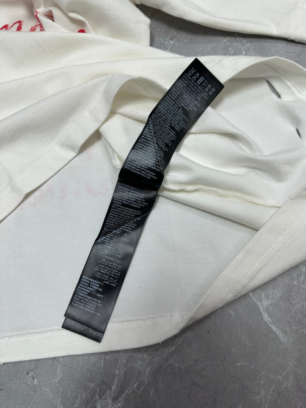 White T-shirt with black size label on fabric fold