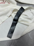White T-shirt with black size label on fabric fold
