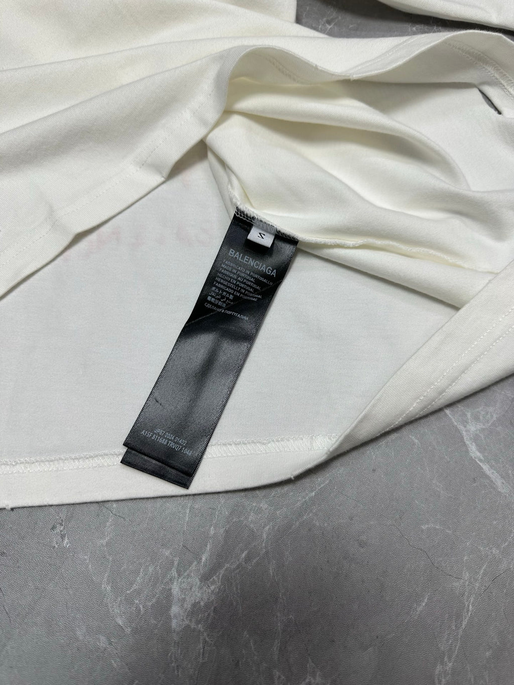 White short-sleeve T-shirt with black size tag inside neckline