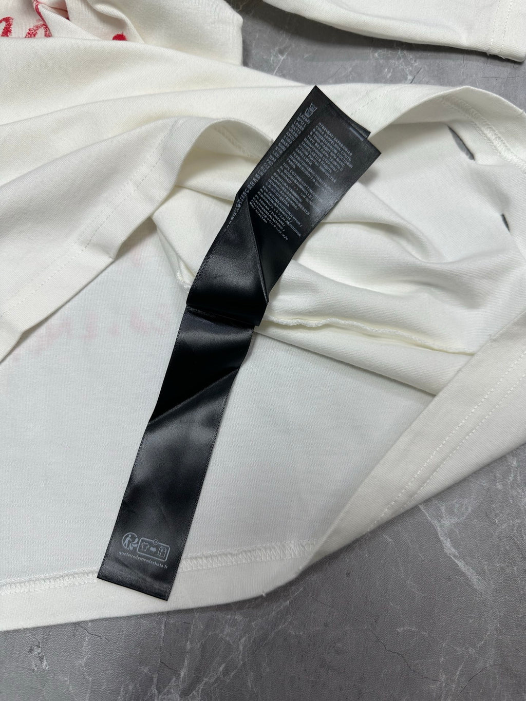 White short-sleeve T-shirt with black brand size label and stitched seam