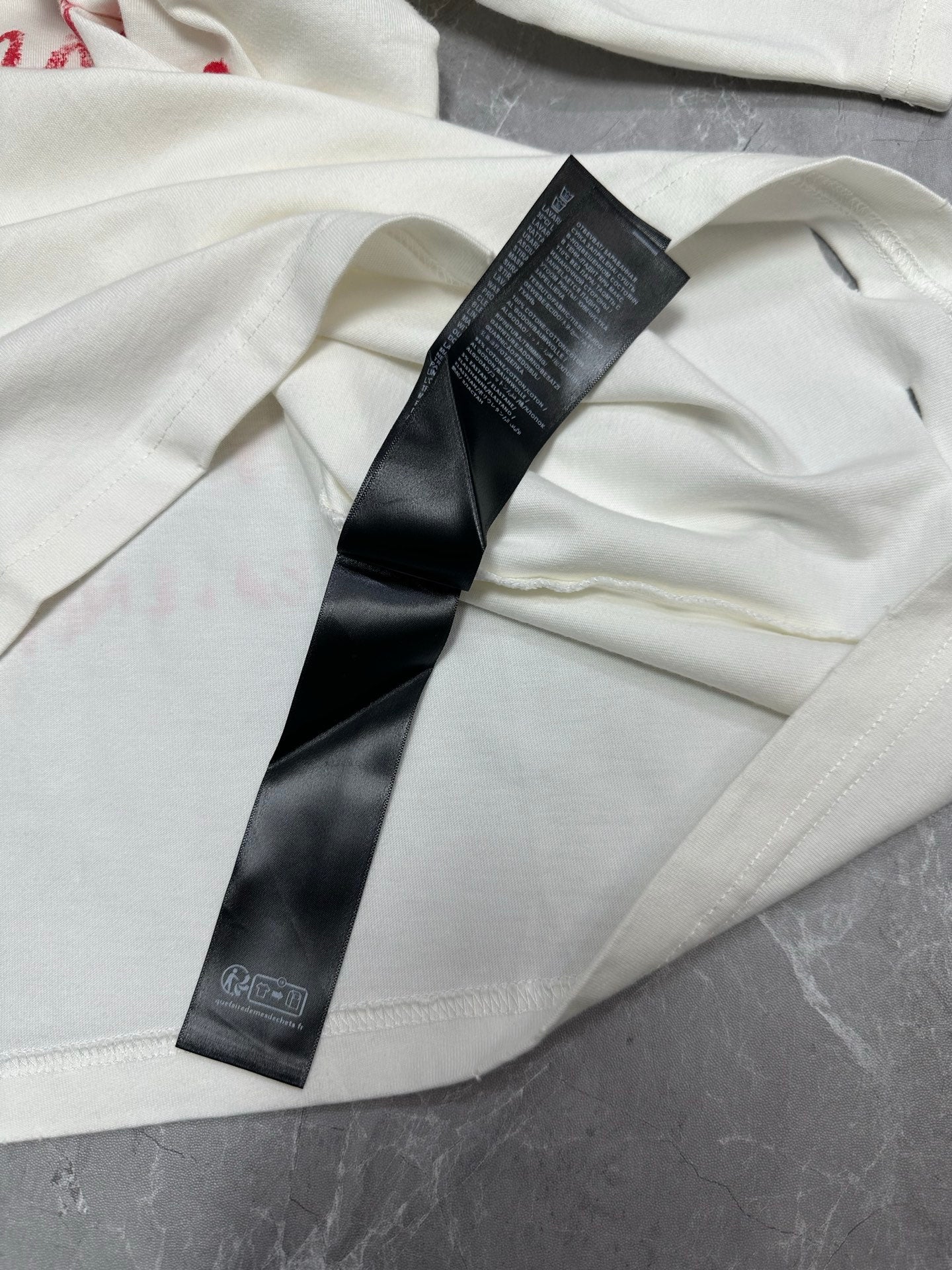 White short-sleeve T-shirt with black brand size label and stitched seam