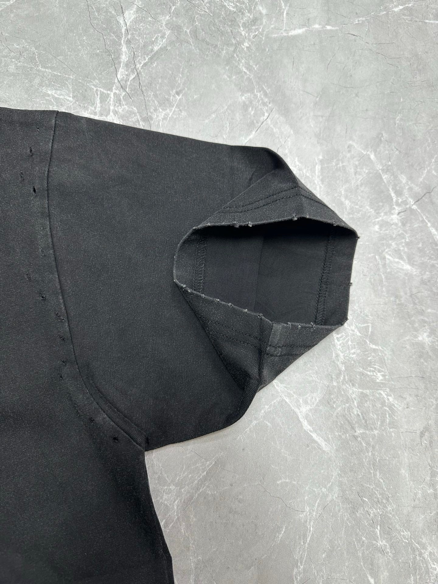 Dark gray short-sleeve T-shirt sleeve cuff and shoulder seam close-up