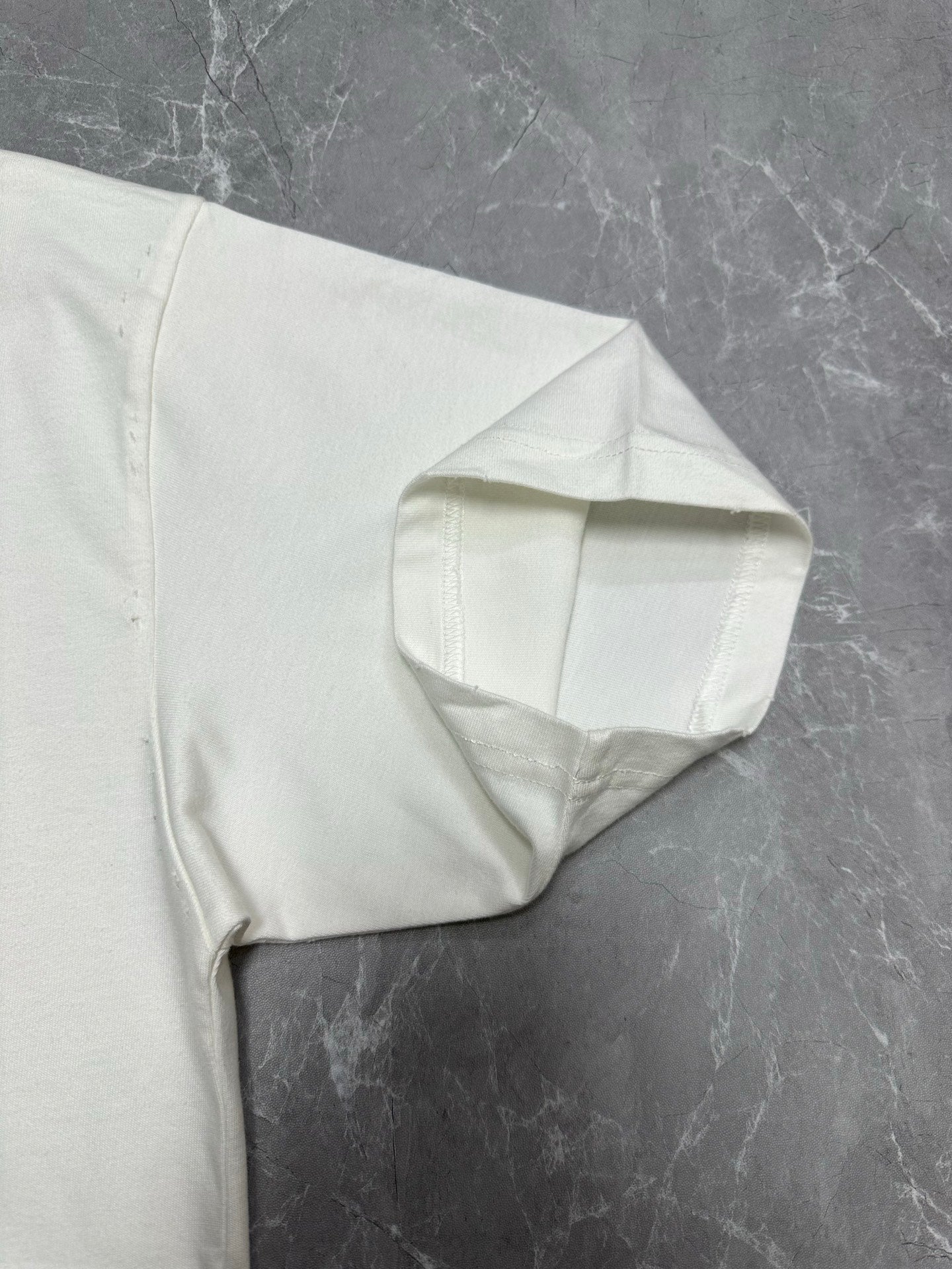 White T-shirt back corner with curved seam detail at hem