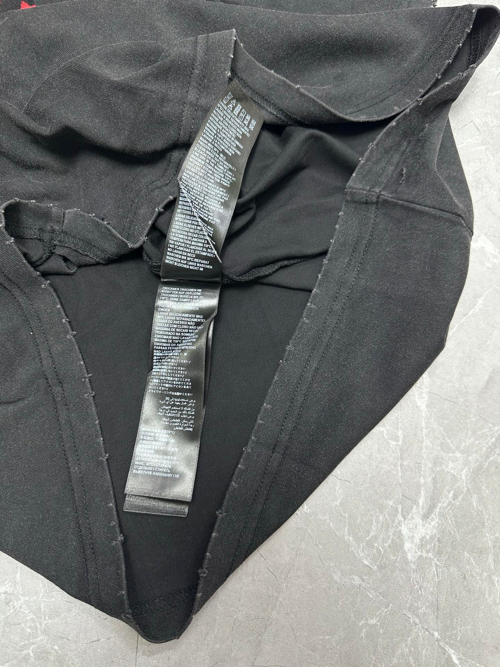 Black T-shirt with V-neck and multiple neck label tags