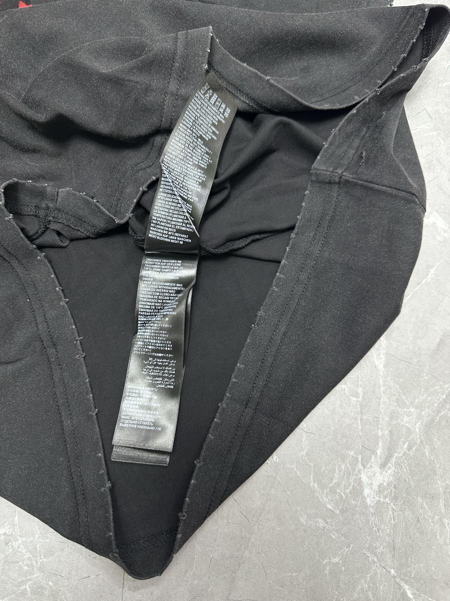 Black T-shirt with V-neck and multiple neck label tags