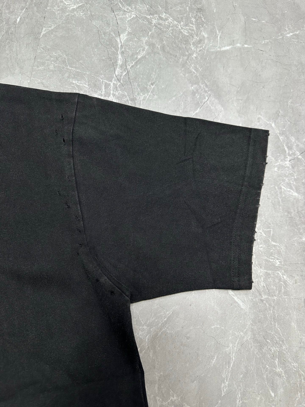 Dark gray short-sleeve T-shirt, side seam and bottom hem close-up