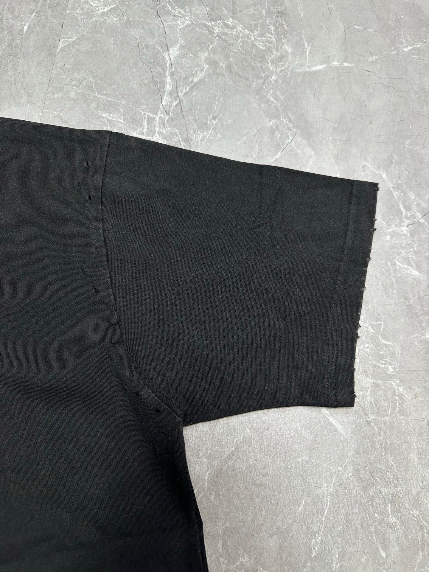 Dark gray short-sleeve T-shirt, side seam and bottom hem close-up