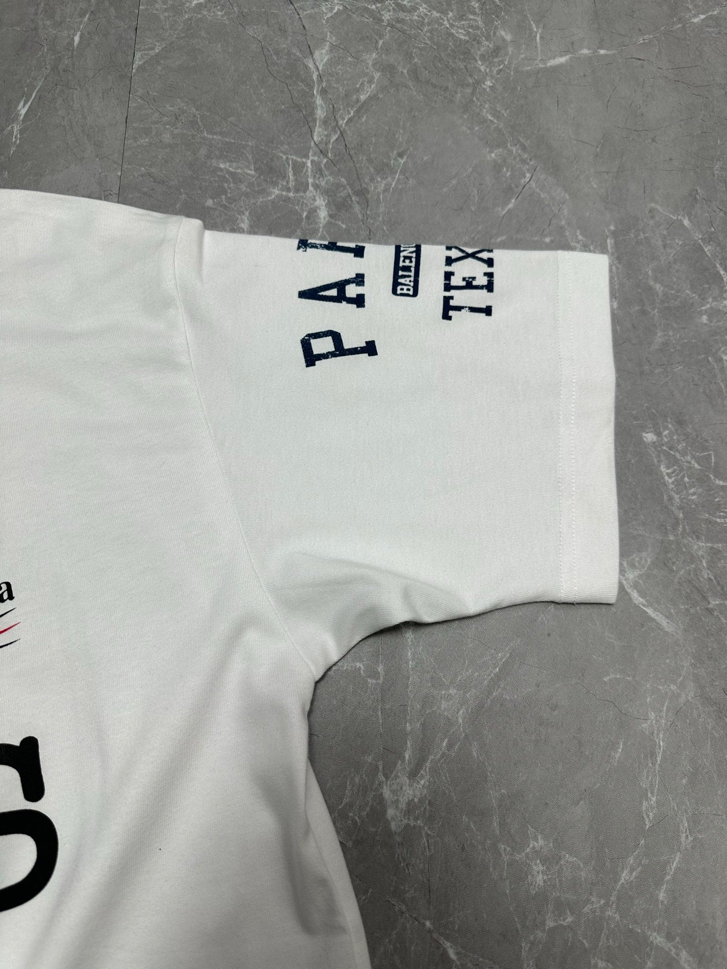 Balenciaga white T-shirt sleeve with vertical PARIS and TYX text
