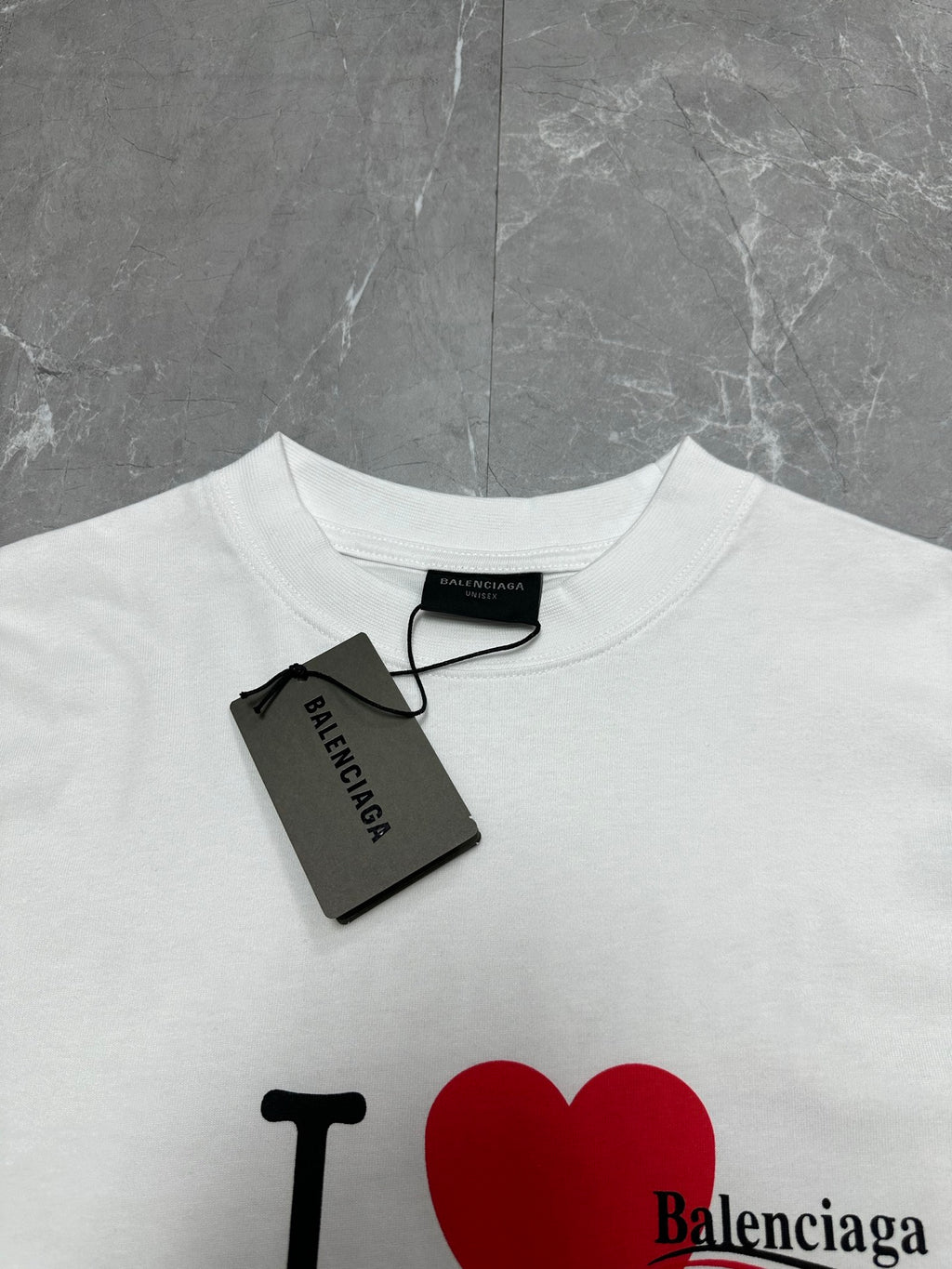 Balenciaga white short-sleeve T-shirt close-up with red heart graphic and neck tag