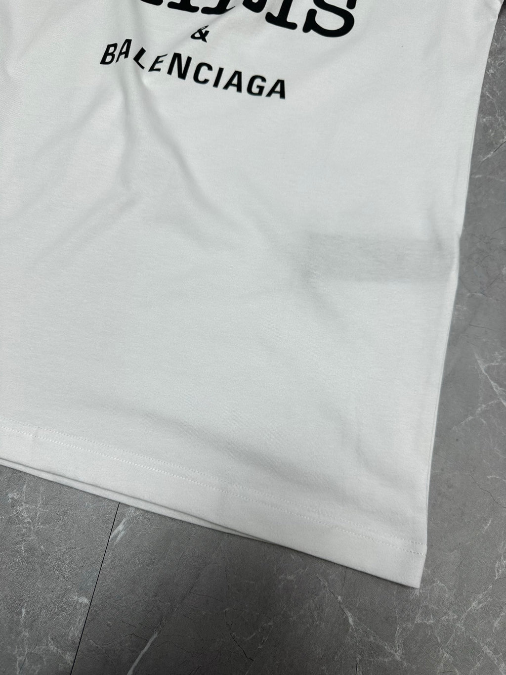 Balenciaga white short-sleeve T-shirt with partial BALENCIAGA text at hem