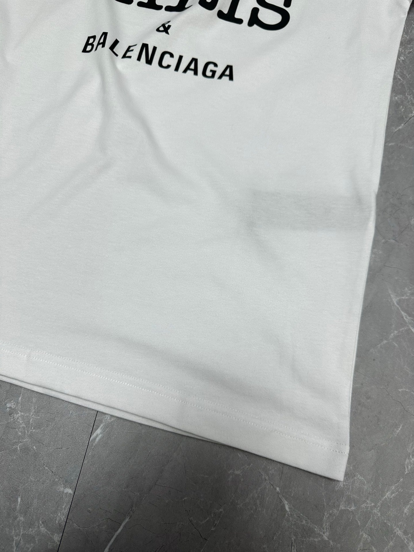 Balenciaga white short-sleeve T-shirt with partial BALENCIAGA text at hem