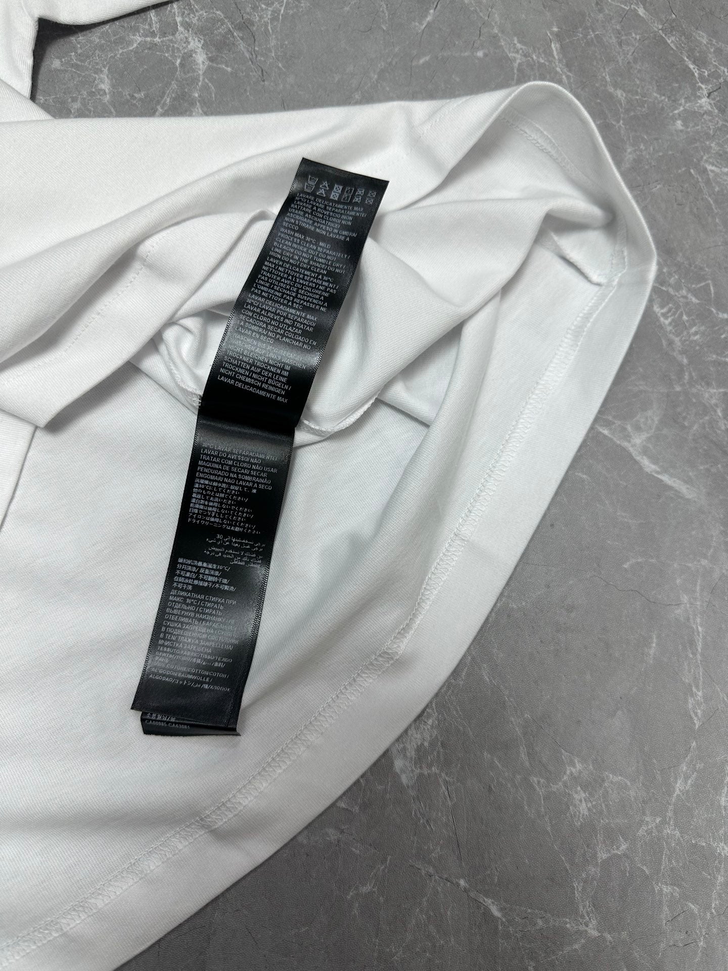 Balenciaga white short-sleeve T-shirt, close-up of care label on inner collar