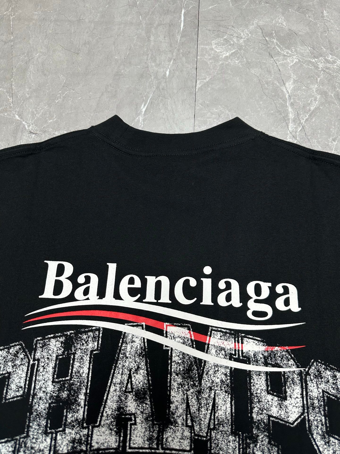 Black short-sleeve T-shirt with large Balenciaga text and red striped graphic.