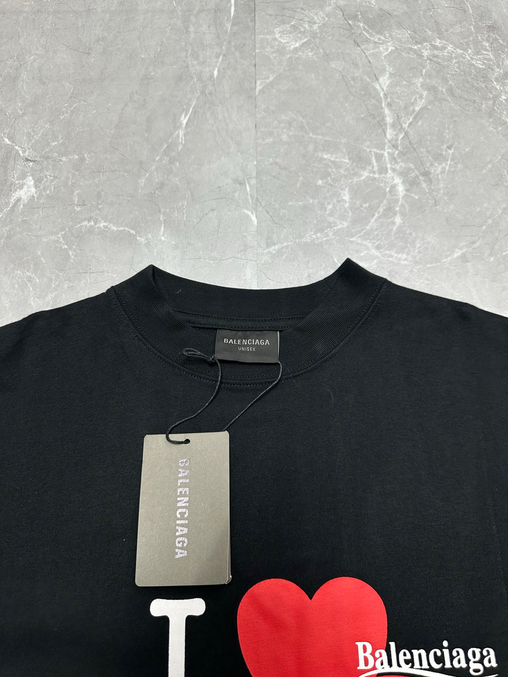 Black short-sleeve T-shirt with Balenciaga neck label and hanging tag.