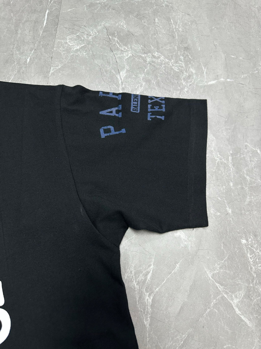 Black short-sleeve T-shirt with blue logo text on sleeve cuff.