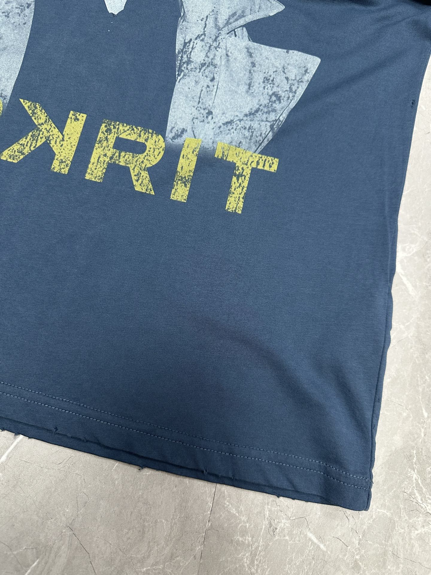 Blue T-shirt front close-up showing PPYRIT yellow lettering and portrait print