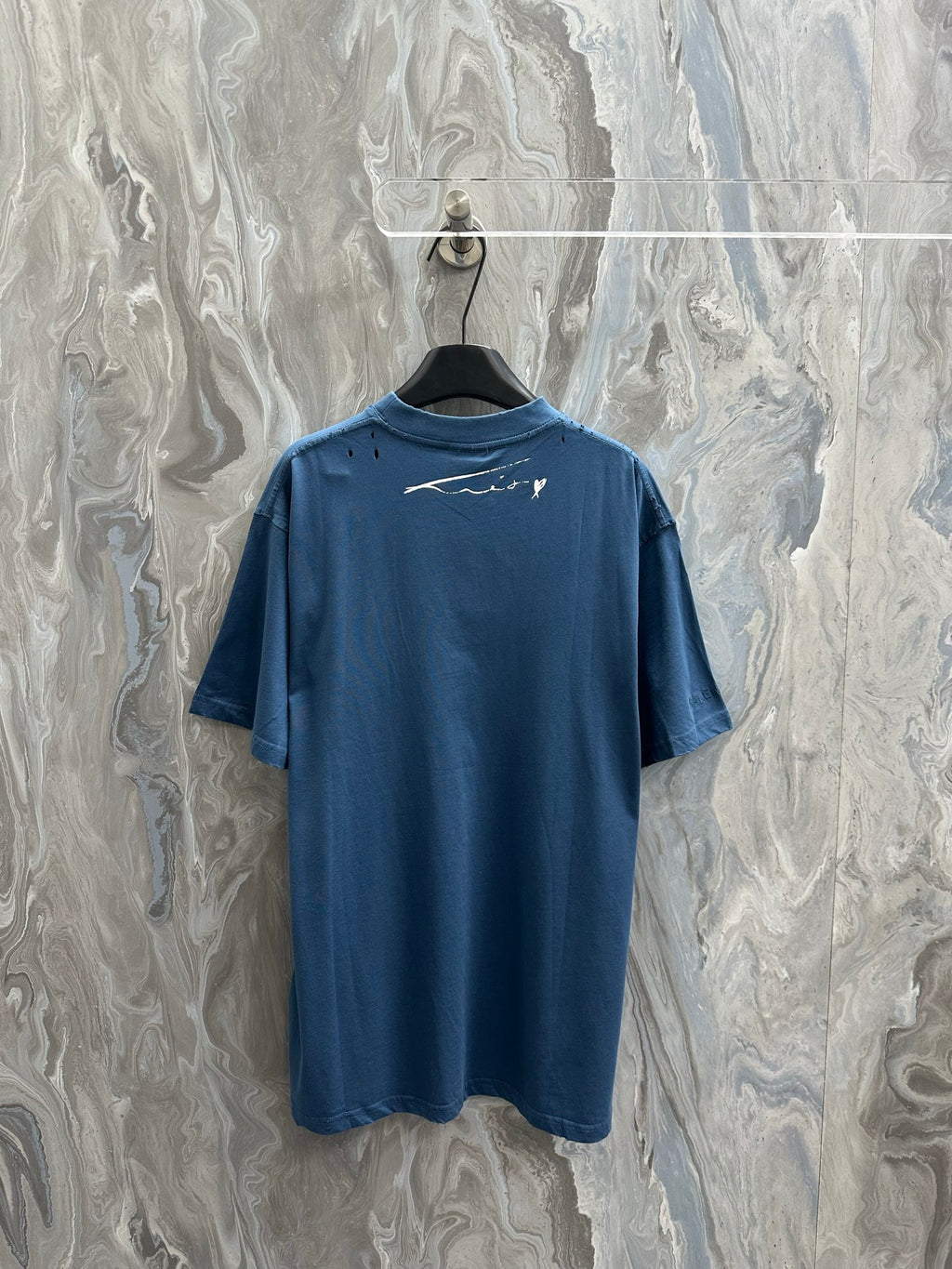 Blue T-shirt with small white logo graphic on the back neckline