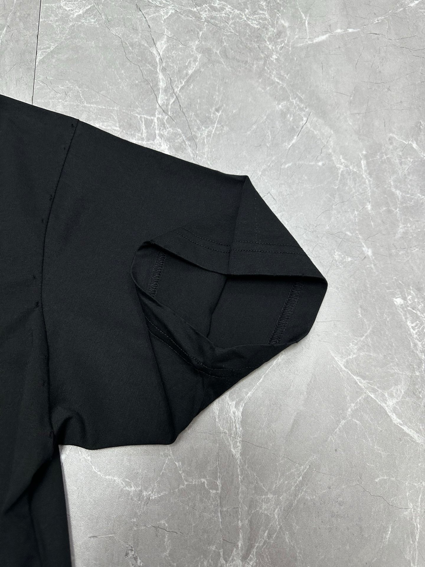 Balenciaga black T-shirt sleeve and side fabric seam close-up