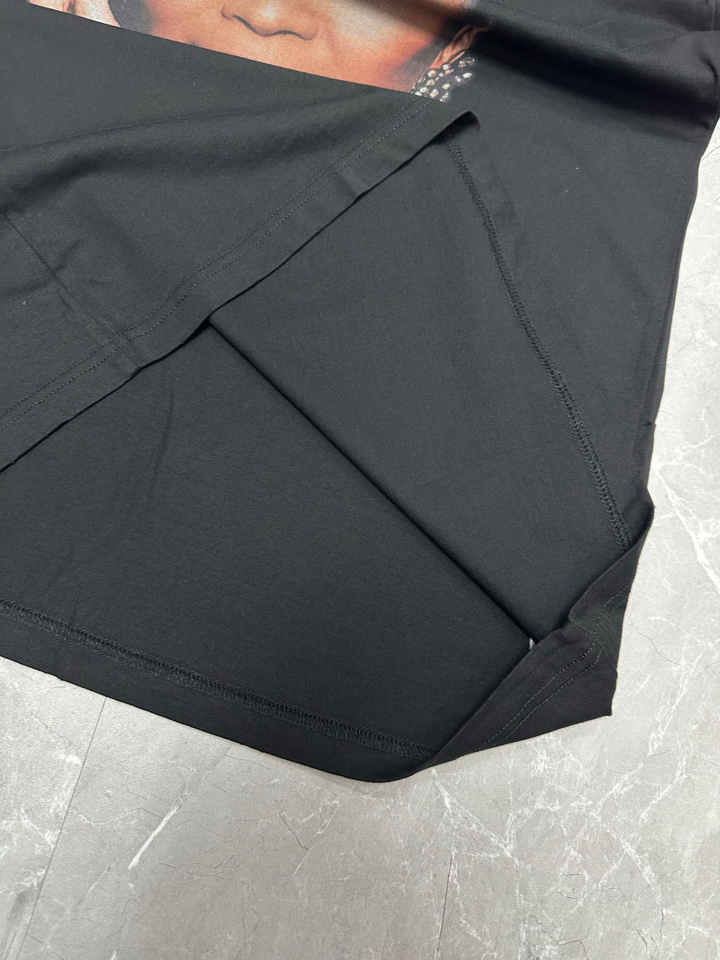 Balenciaga black T-shirt side seam and draped fabric close-up