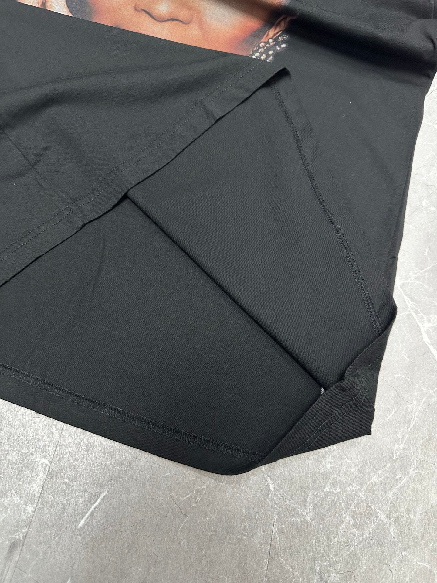 Balenciaga black T-shirt side seam and draped fabric close-up