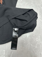Black short-sleeve T-shirt with care tag and folded sleeve close-up