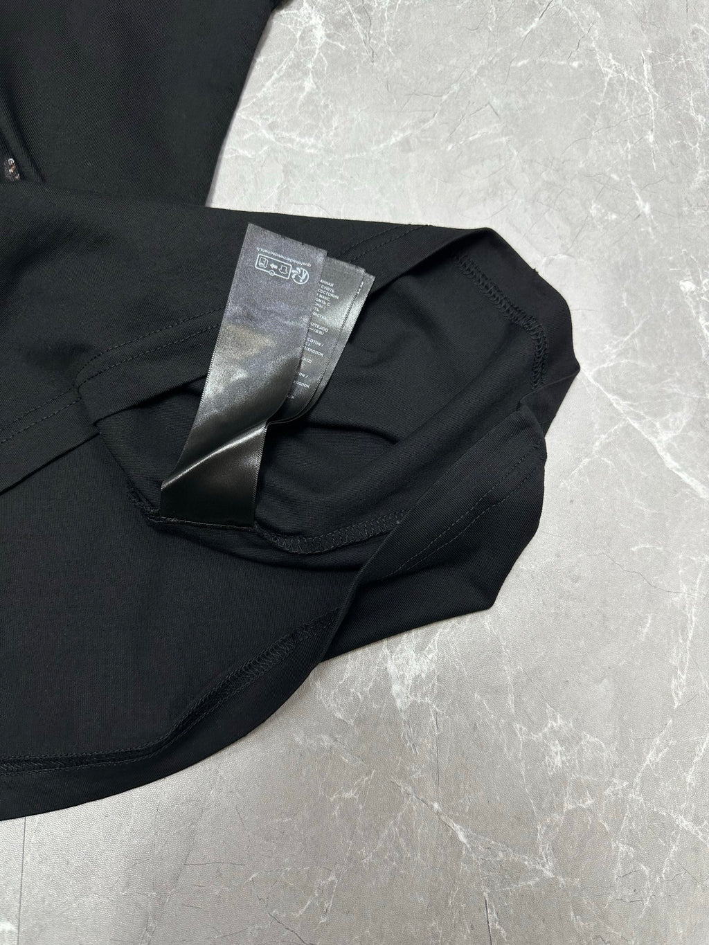 Black short-sleeve T-shirt with care tag on folded collar close-up