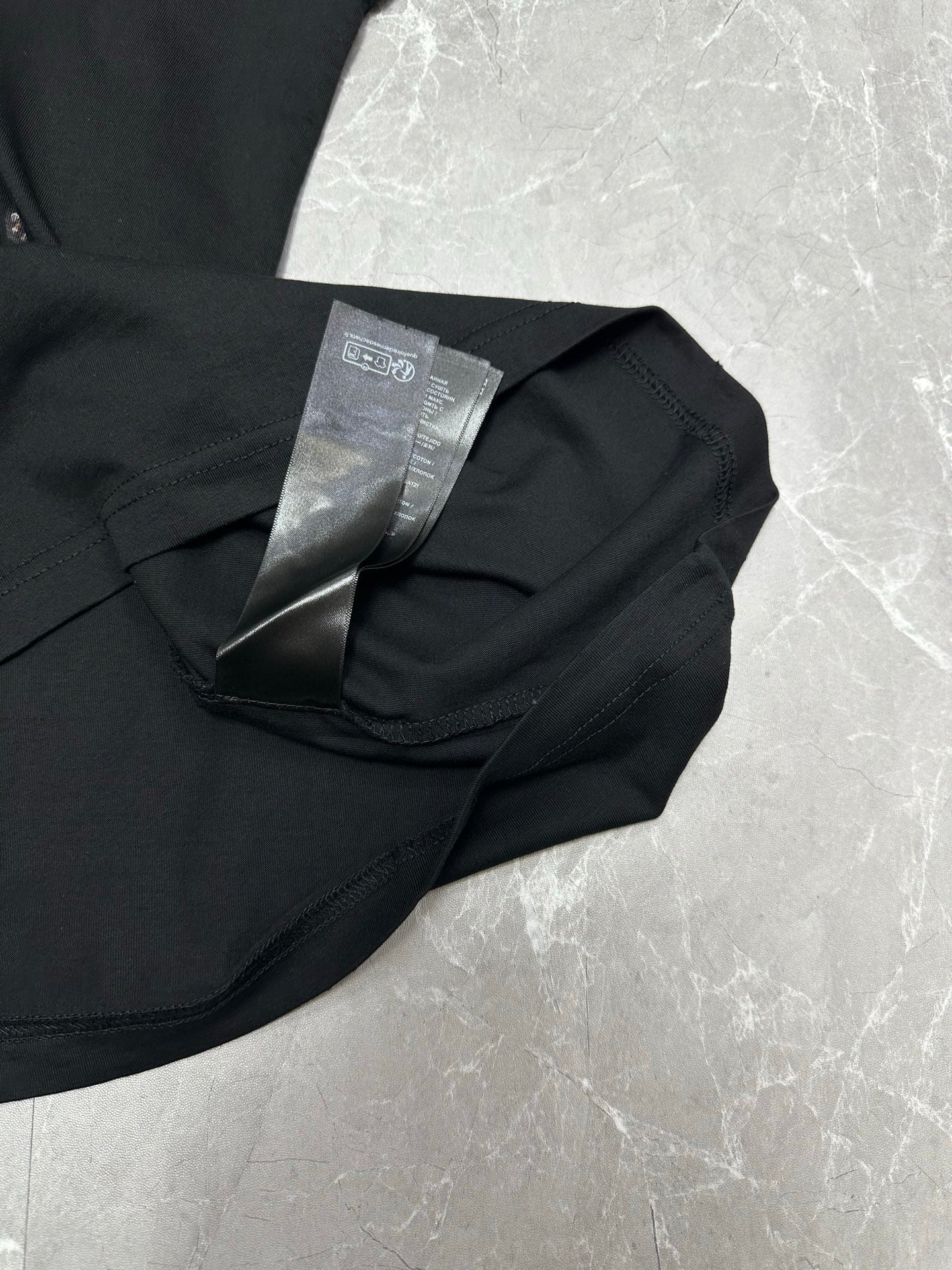 Black short-sleeve T-shirt with care tag on folded collar close-up