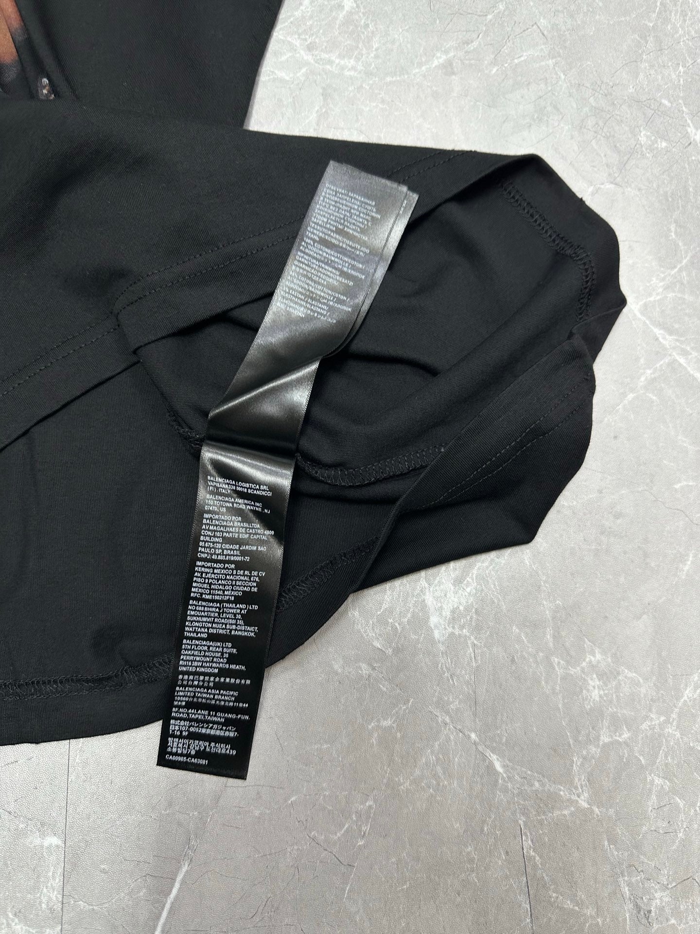 Black short-sleeve T-shirt with printed care label on folded fabric