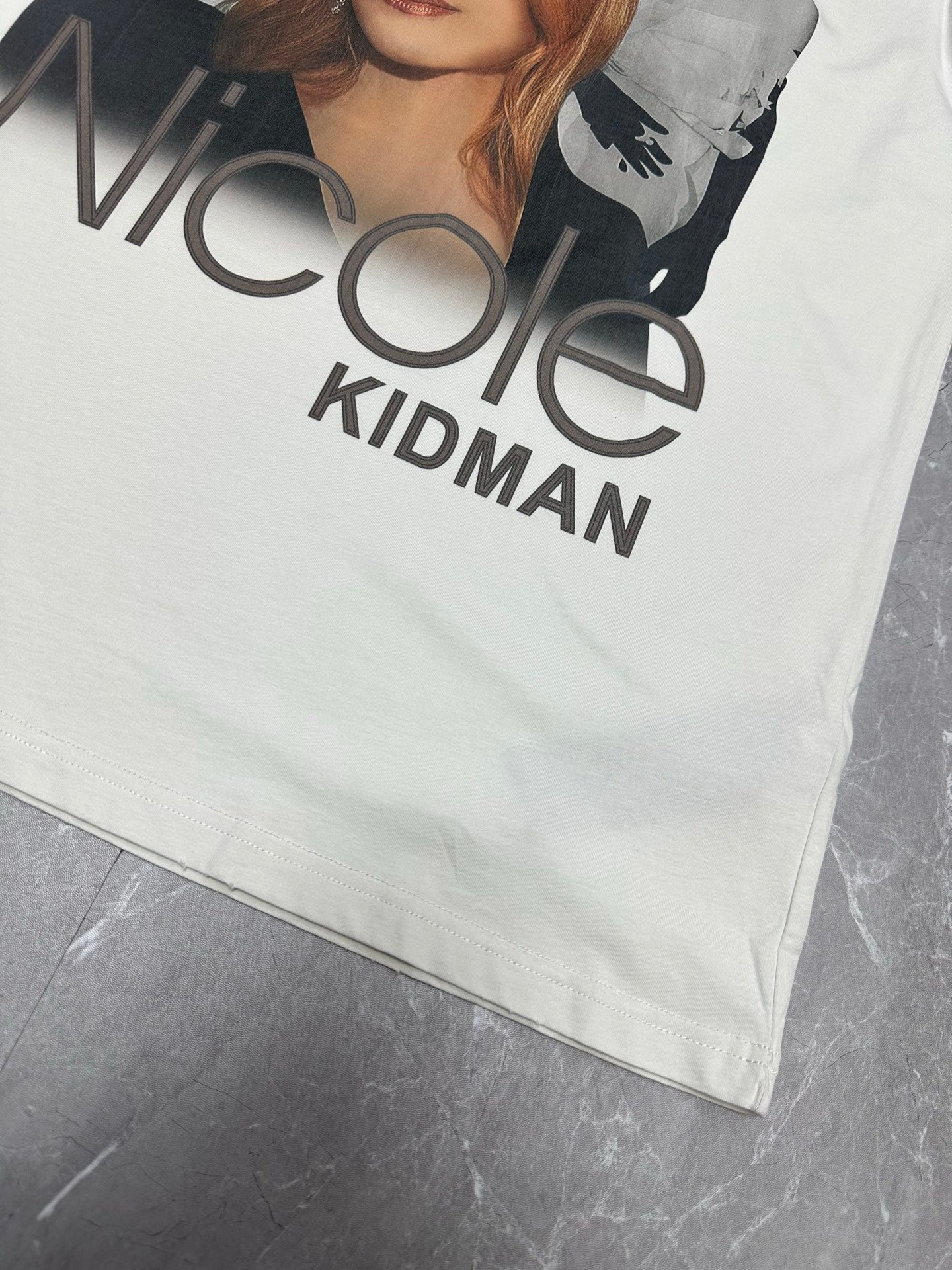 White T-shirt front corner with large “Nicole Kidman” graphic text