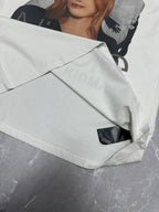 White graphic T-shirt with black side label near the hem and folded front