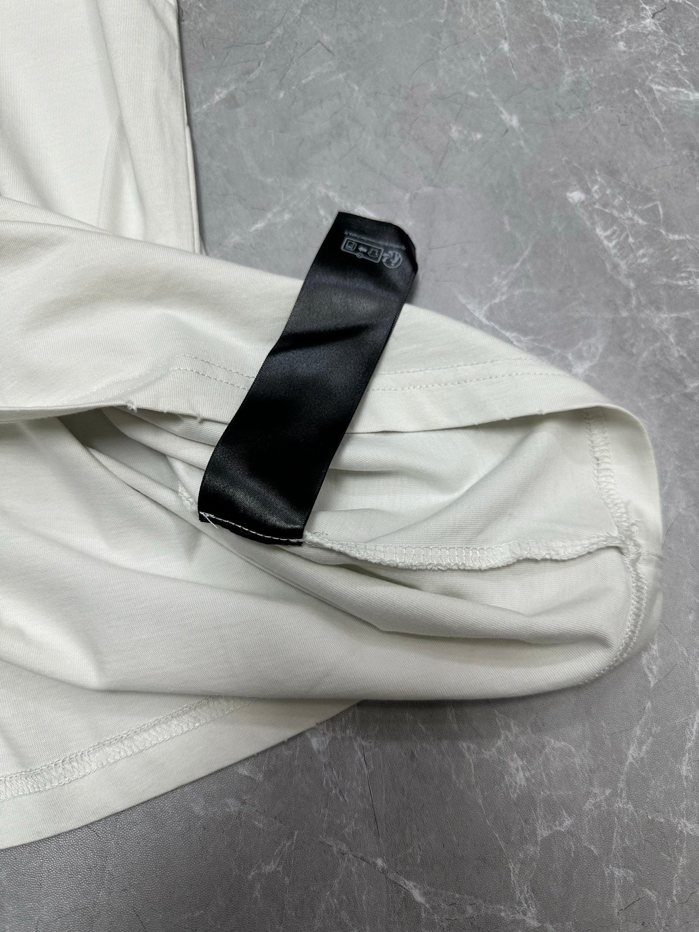 White T-shirt hem with black care label tag