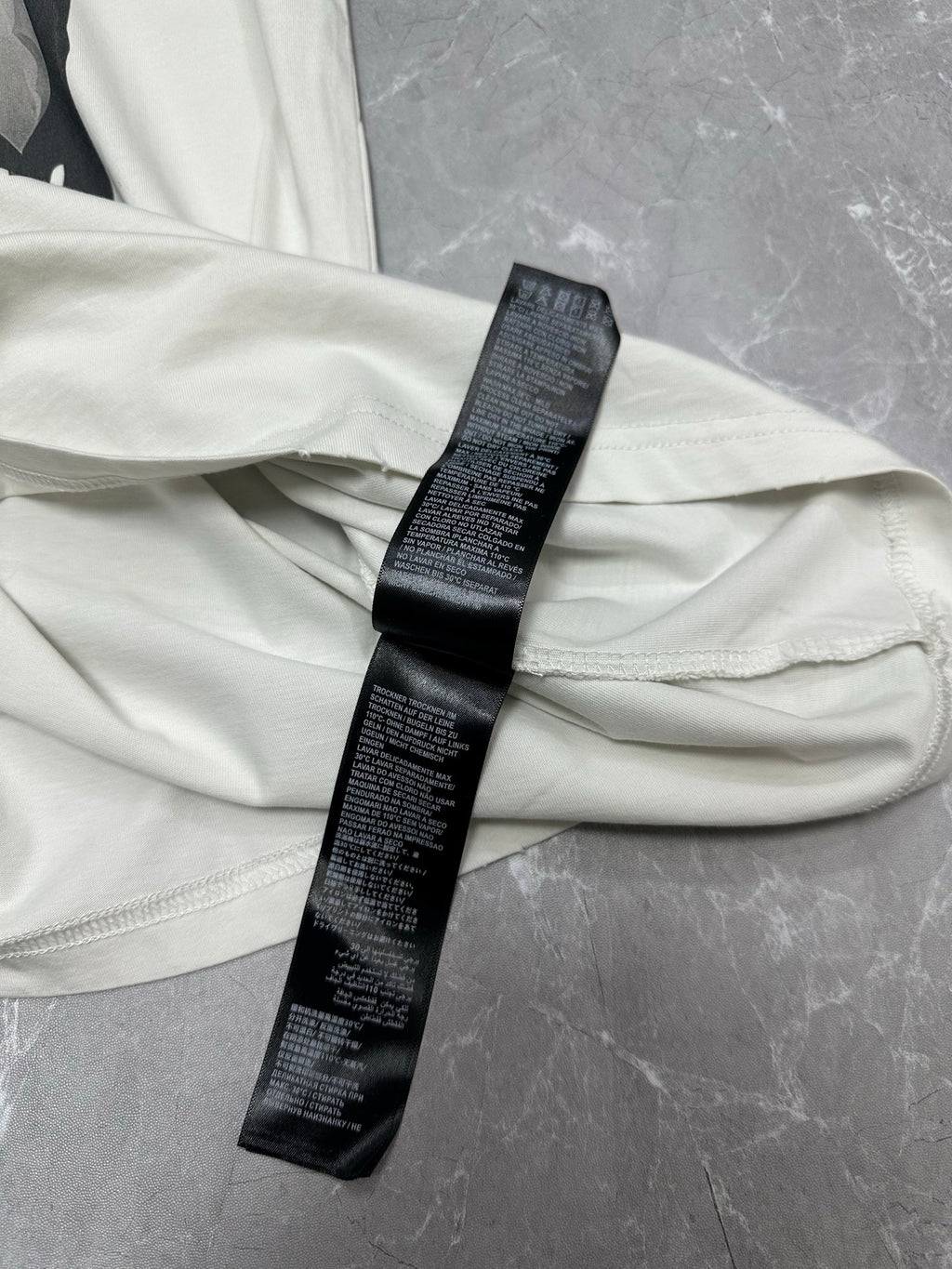 White T-shirt back with black care label strip along collar area
