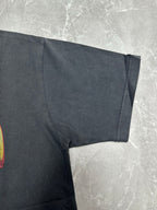 Dark charcoal graphic T-shirt short sleeve and draped fabric detail near hem