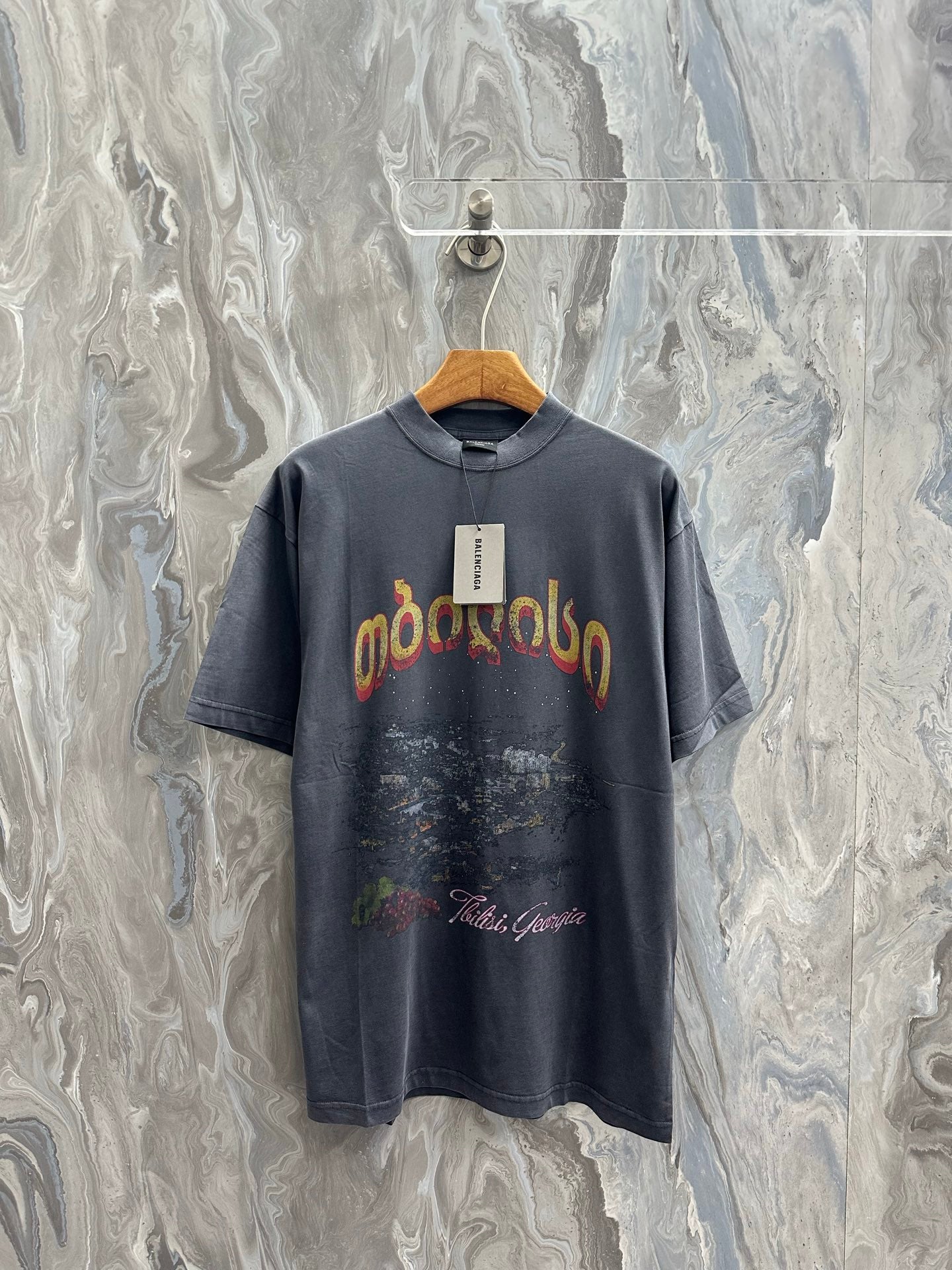 Dark charcoal graphic T-shirt with short sleeves and large front logo print