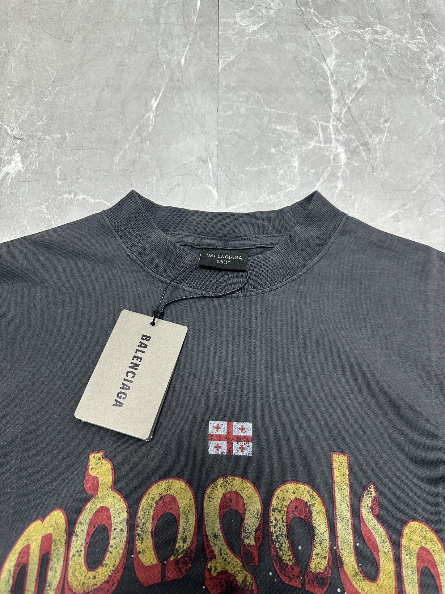 Dark charcoal graphic T-shirt neckline and front print with hanging price tag