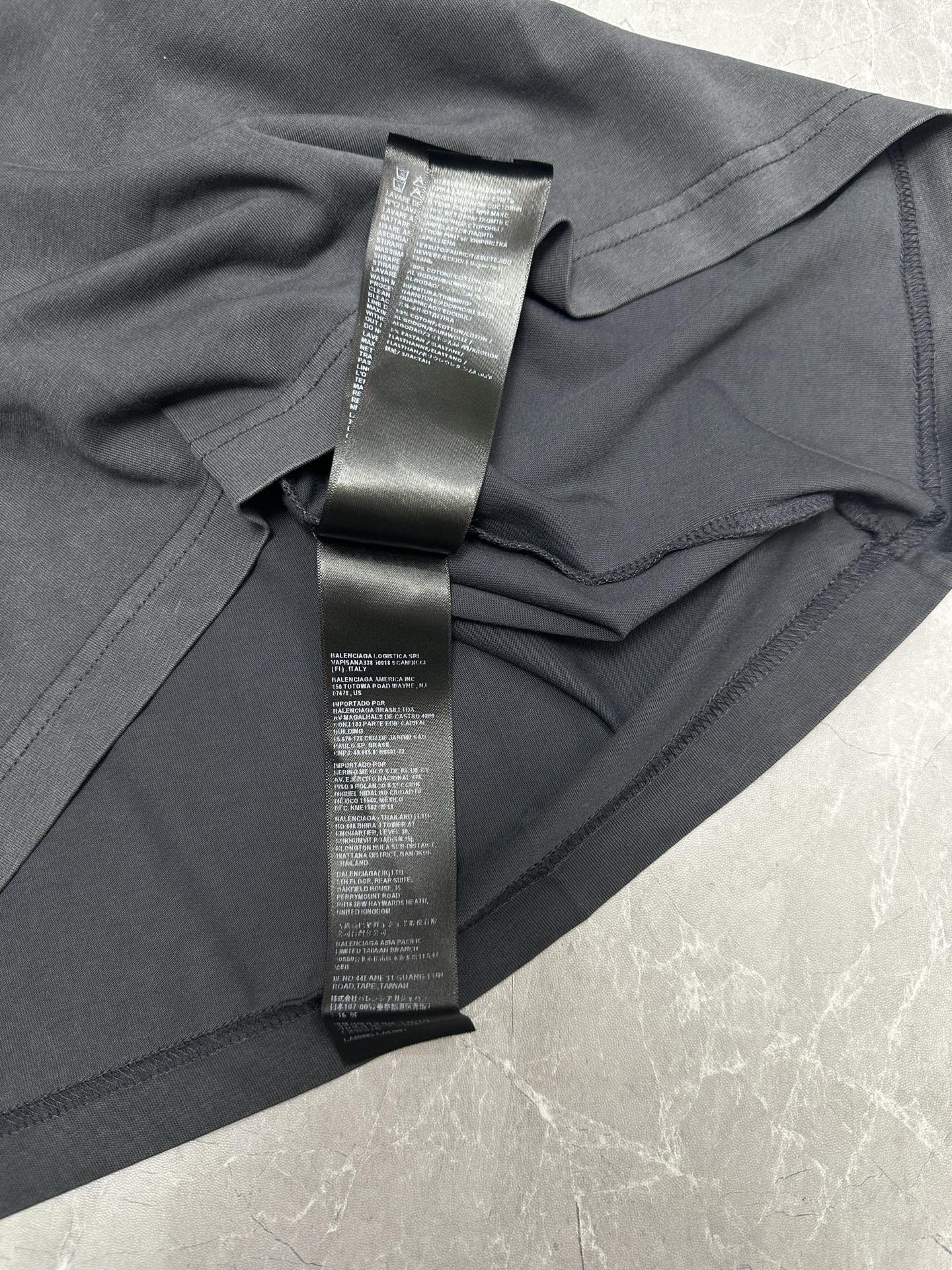 Dark gray T-shirt side view with folded fabric and long BALENCIAGA label