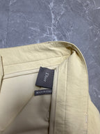 Cream cargo shorts with back yoke seam and fabric label on waistband.
