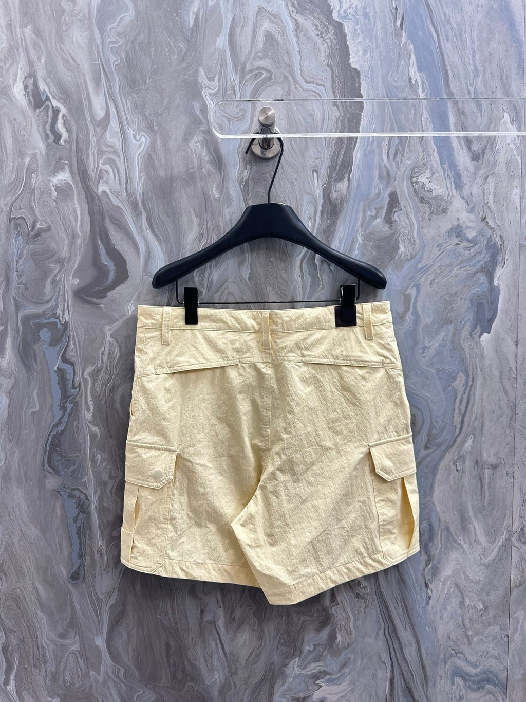 Cream cargo shorts with belt loops, button fly, and back patch pocket.