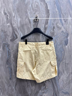 Cream cargo shorts with belt loops, button fly, and back patch pocket.