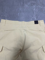 Cream cargo shorts with belt loops and back patch pockets.