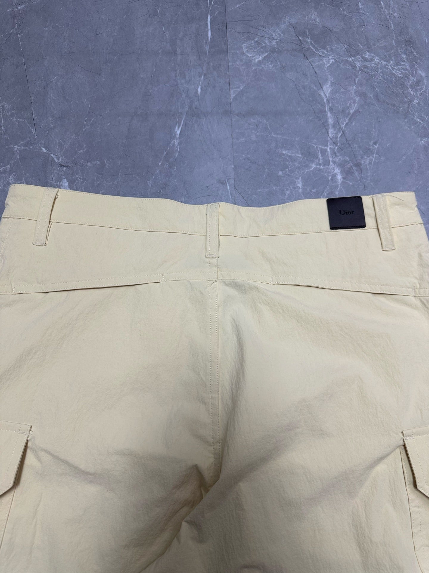Cream cargo shorts with belt loops and back patch pockets.