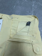 Cream cargo shorts with button closure and inner waistband label.
