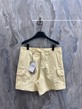 Cream cargo shorts with belt loops, button fly, and side cargo pockets.