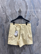 Cream cargo shorts with belt loops, button fly, and side cargo pockets.