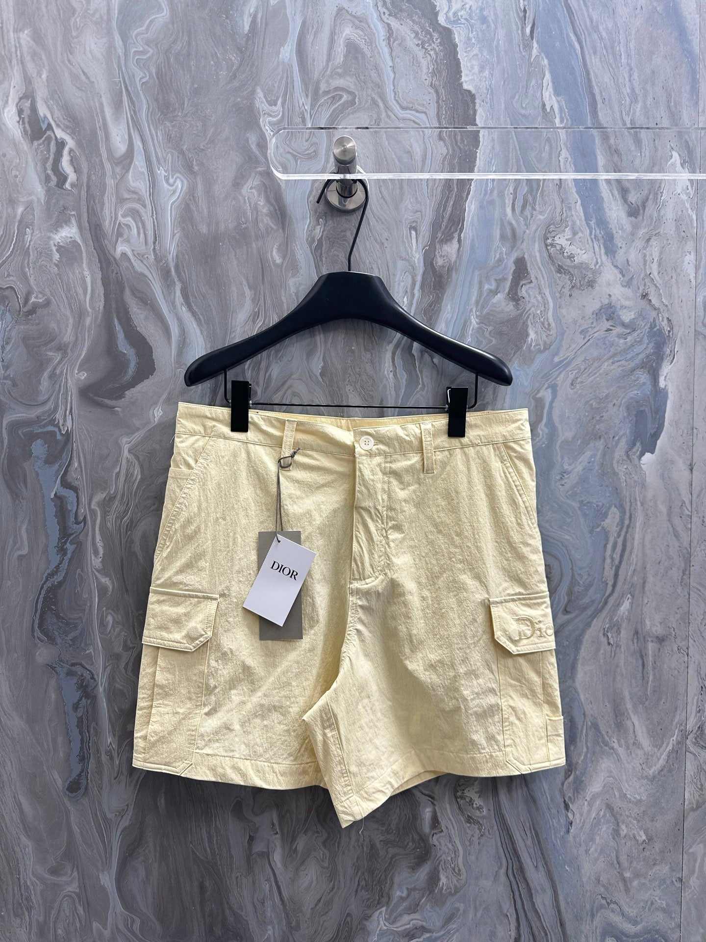 Cream cargo shorts with belt loops, button fly, and side cargo pockets.