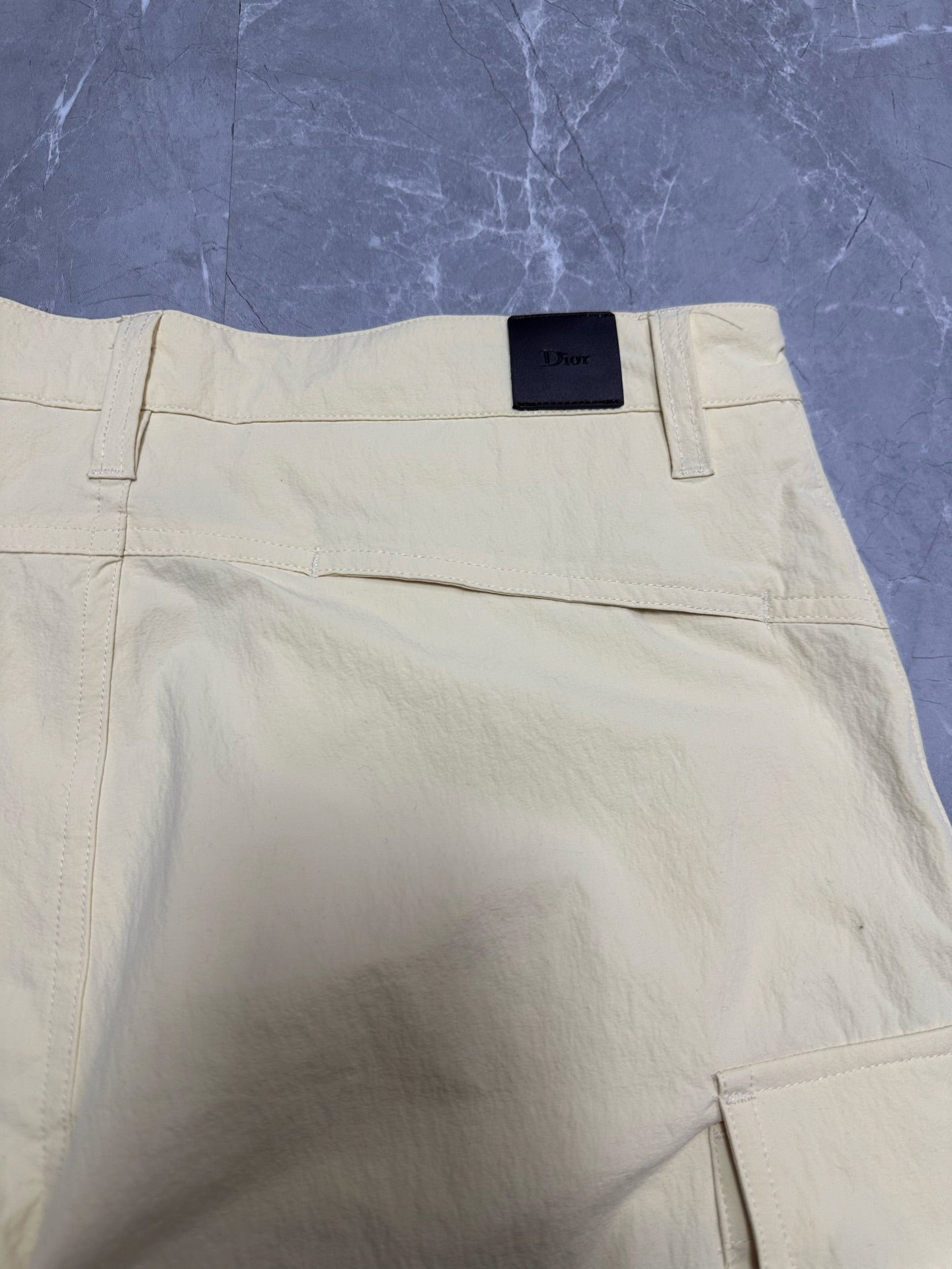 Cream cargo shorts with waistband and patch pocket detail at hem.