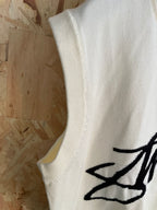 White sleeveless knit vest side with ribbed armhole and partial Stussy graphic