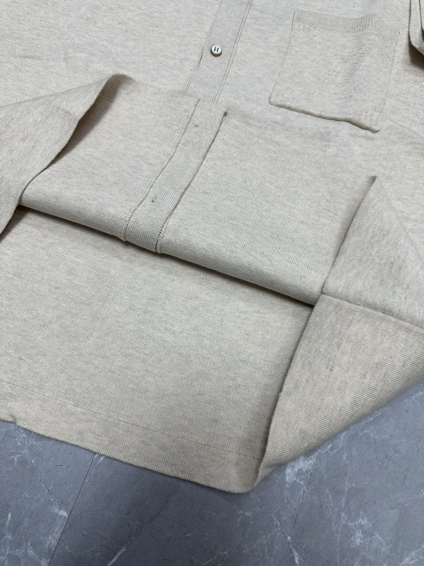 Light beige polo shirt front placket and chest pocket, button details
