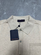 Light beige polo shirt with pointed collar and button placket, with neck tag